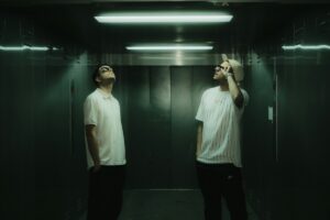 a couple of men standing in a bathroom next to each other